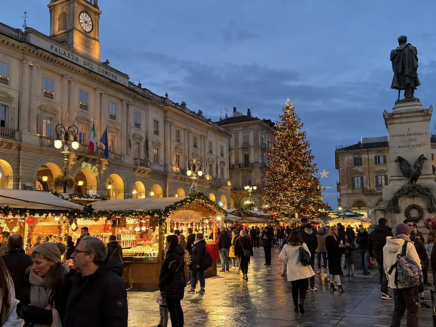 Casette dei mercatini di Natale e grande albero illuminato in piazza davanti al Palazzo del Comune di Alessandria