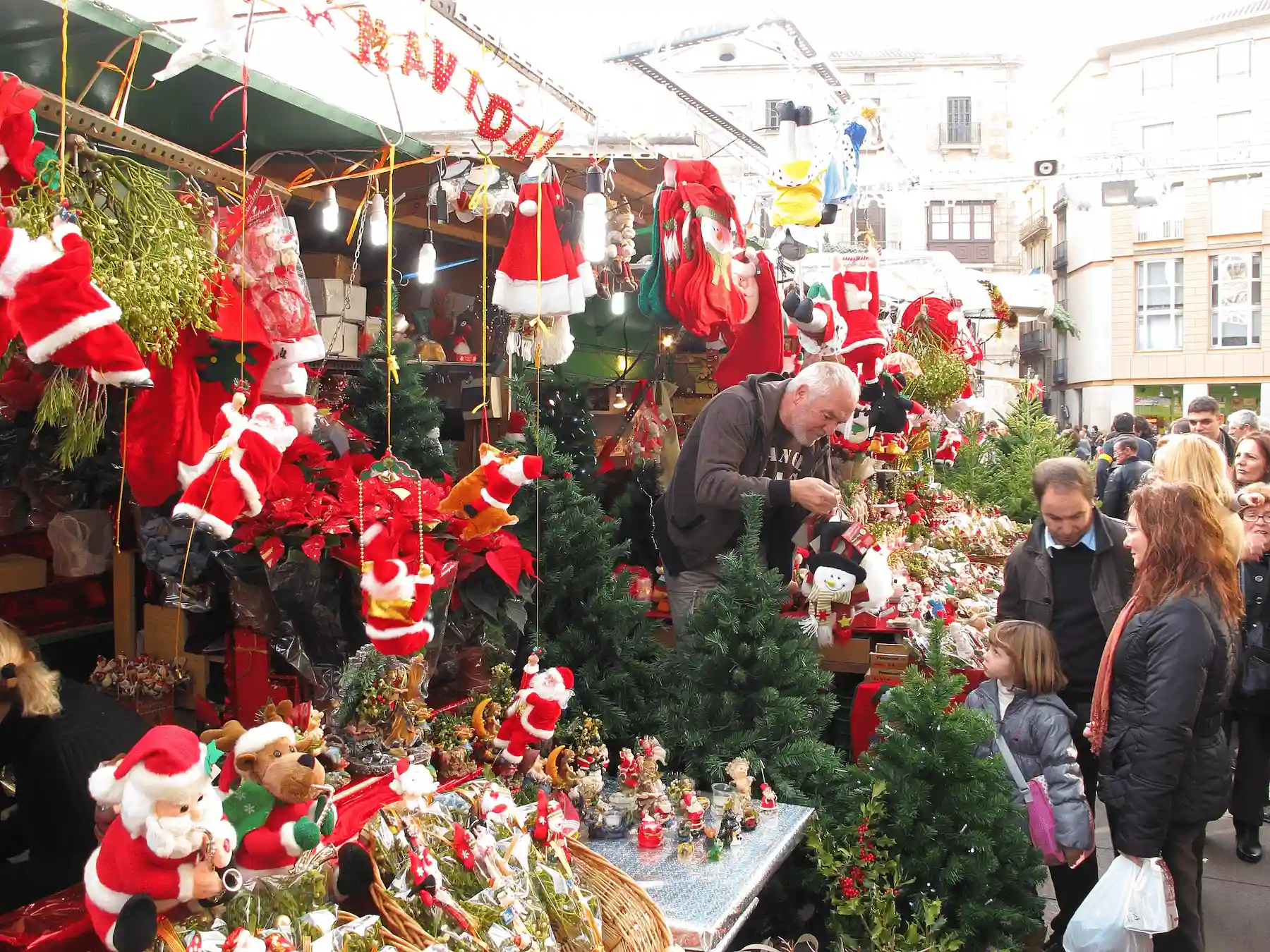 Bancarella con Babbi Natale, ghirlande e addobbi rossi e visitatori - mercatini di Natale di Fontanellato