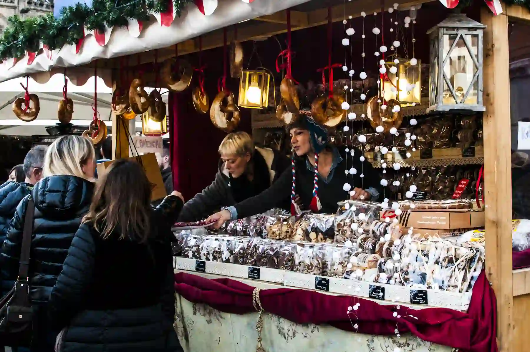 Bancarella di dolci e biscotti con venditori e lanterne appese - mercatini di Natale di Rimini