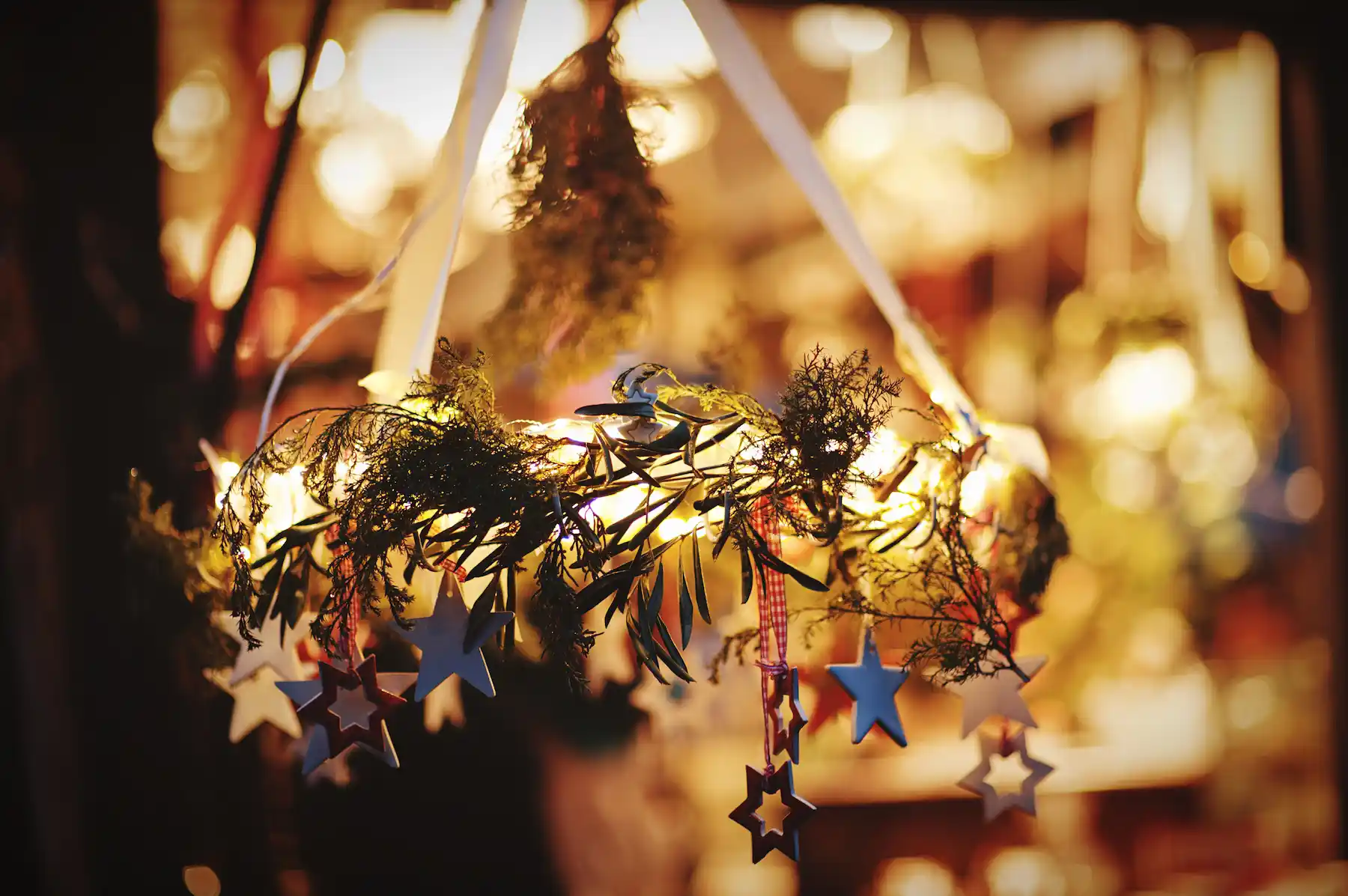 Decorazione natalizia con ghirlanda di rami, stelle di legno e luci calde - mercatini di Natale di Venzone