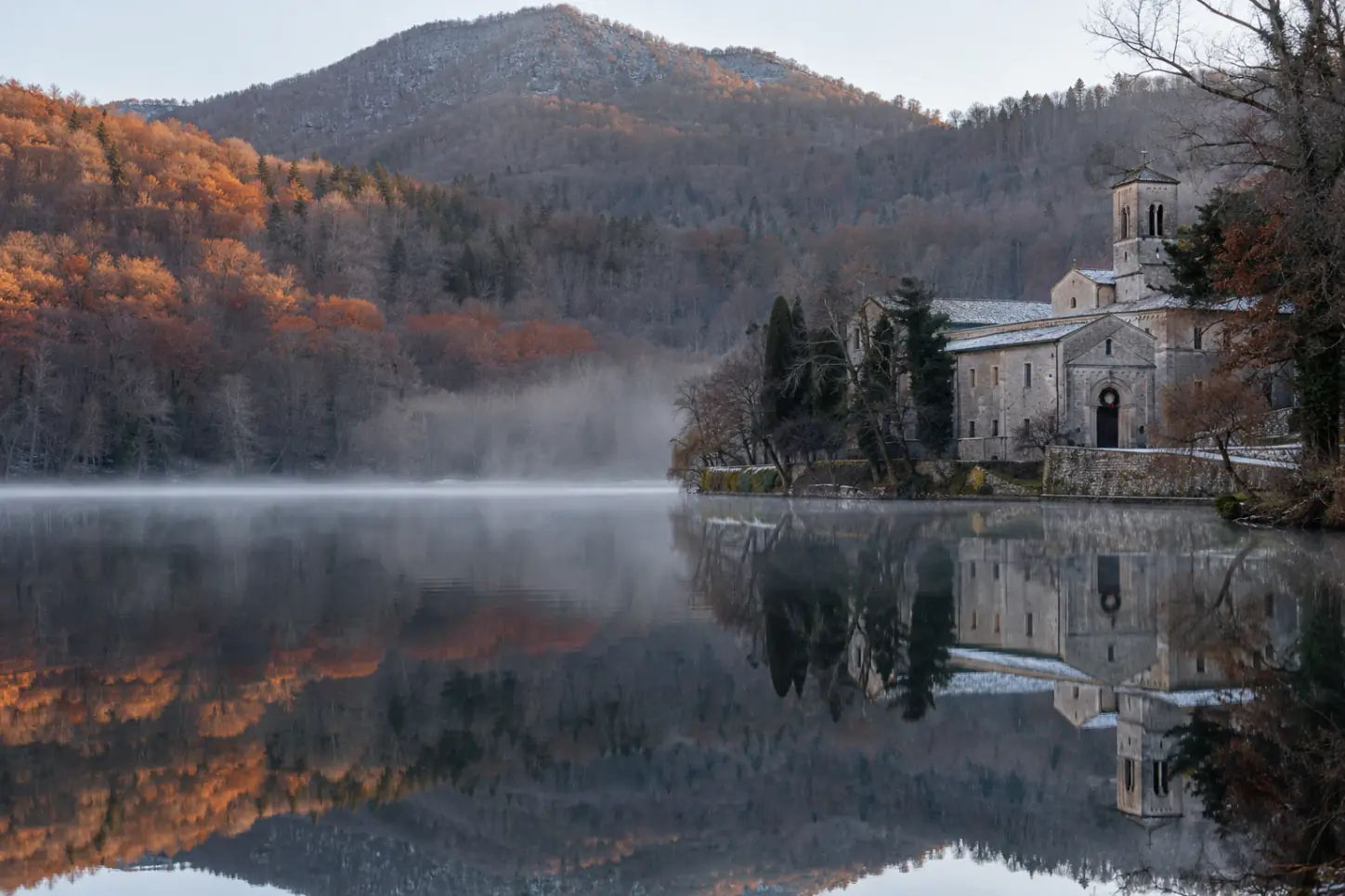 I Laghi di Monticchio sul Vulture in inverno, con l'abbazia di San Michele sulla riva e i boschi nella nebbia mattutina