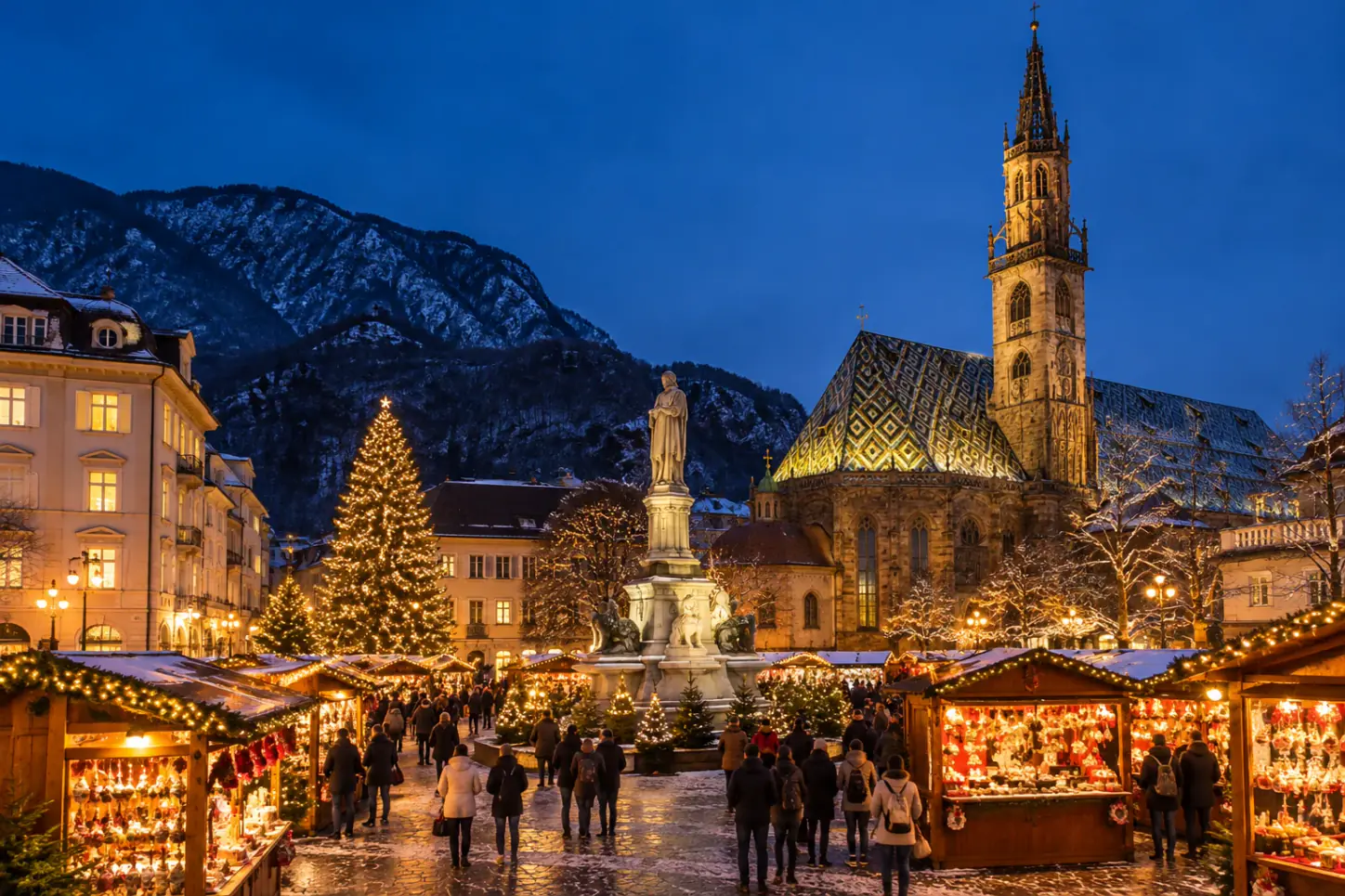 Casette di legno del mercatino di Natale di Bolzano in Piazza Walther al tramonto, con il Duomo gotico dal tetto di tegole colorate