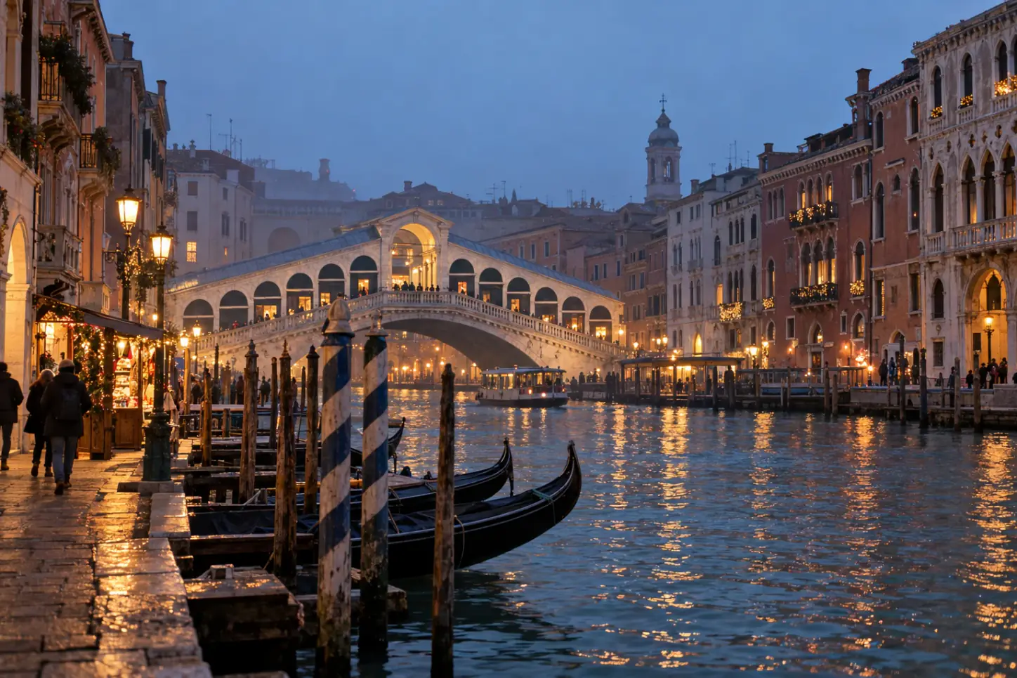 Il Canal Grande a Venezia in inverno con il Ponte di Rialto, le gondole, i palazzi illuminati e la leggera nebbia